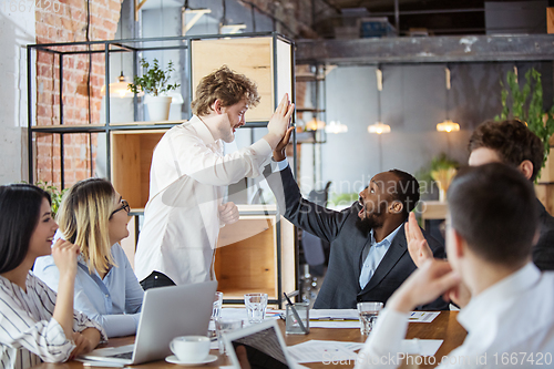 Image of Diverse group of co-workers having casual discussion in office. Executives during friendly discussion, month reporting, creative meeting