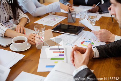 Image of Close up hands of co-workers having casual discussion in office. Executives during friendly discussion, month reporting, creative meeting