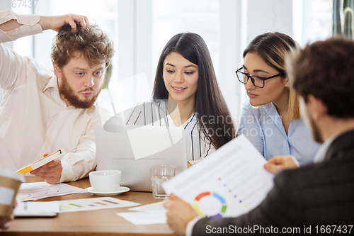 Image of Diverse group of co-workers having casual discussion in office. Executives during friendly discussion, month reporting, creative meeting