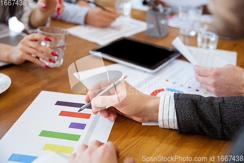 Image of Close up hands of co-workers having casual discussion in office. Executives during friendly discussion, month reporting, creative meeting