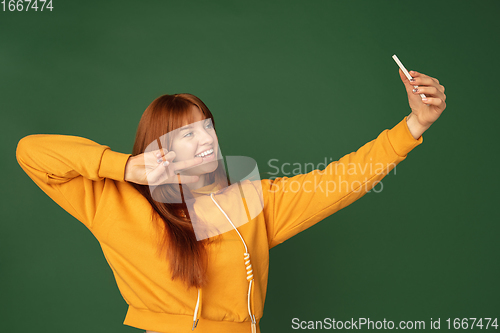 Image of Caucasian woman\'s portrait isolated on green studio background with copyspace