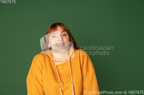 Image of Caucasian woman\'s portrait isolated on green studio background with copyspace