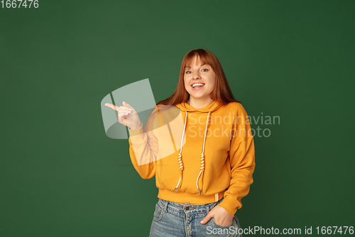 Image of Caucasian woman\'s portrait isolated on green studio background with copyspace