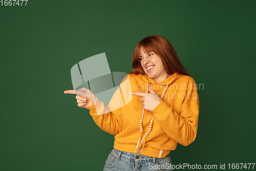 Image of Caucasian woman\'s portrait isolated on green studio background with copyspace