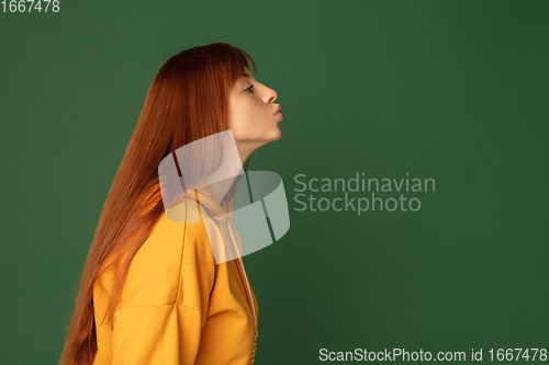 Image of Caucasian woman\'s portrait isolated on green studio background with copyspace