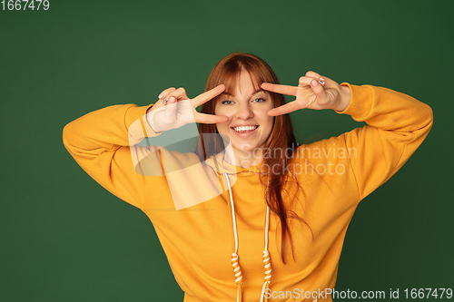 Image of Caucasian woman\'s portrait isolated on green studio background with copyspace