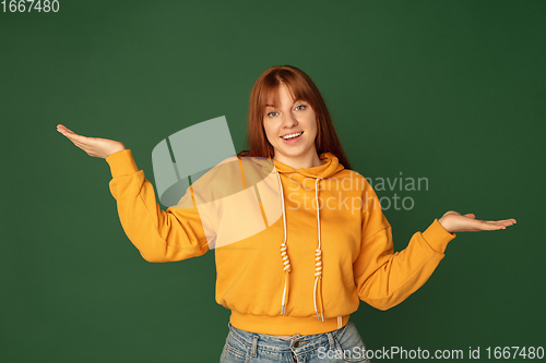 Image of Caucasian woman\'s portrait isolated on green studio background with copyspace