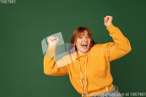 Image of Caucasian woman\'s portrait isolated on green studio background with copyspace