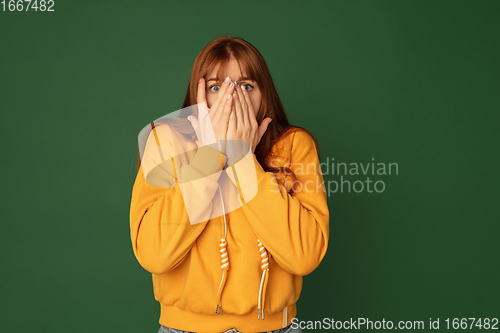 Image of Caucasian woman\'s portrait isolated on green studio background with copyspace