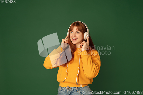 Image of Caucasian woman\'s portrait isolated on green studio background with copyspace