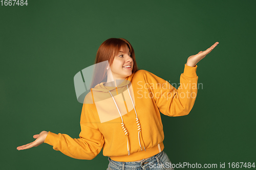 Image of Caucasian woman\'s portrait isolated on green studio background with copyspace