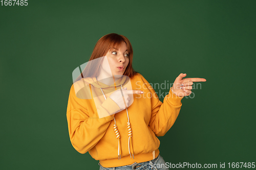 Image of Caucasian woman\'s portrait isolated on green studio background with copyspace