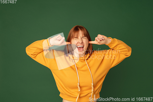 Image of Caucasian woman\'s portrait isolated on green studio background with copyspace