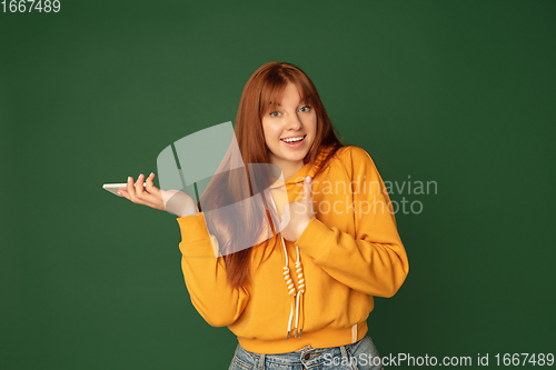 Image of Caucasian woman\'s portrait isolated on green studio background with copyspace