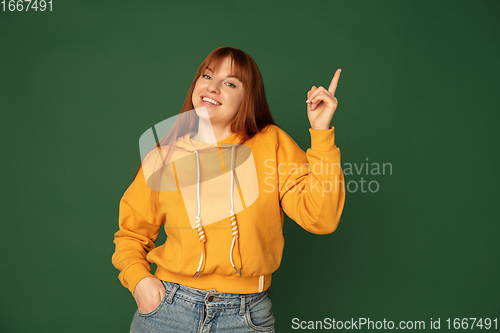 Image of Caucasian woman\'s portrait isolated on green studio background with copyspace