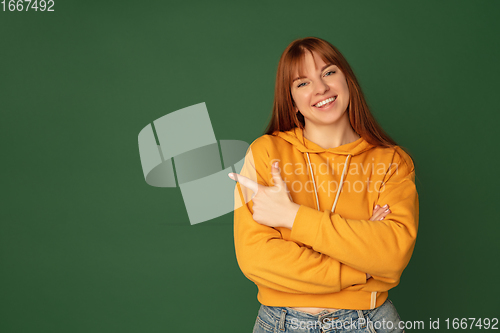 Image of Caucasian woman\'s portrait isolated on green studio background with copyspace