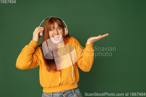 Image of Caucasian woman\'s portrait isolated on green studio background with copyspace