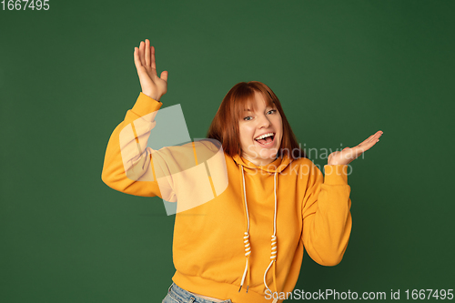 Image of Caucasian woman\'s portrait isolated on green studio background with copyspace