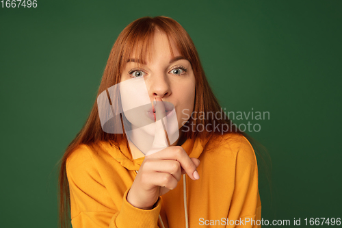 Image of Caucasian woman\'s portrait isolated on green studio background with copyspace