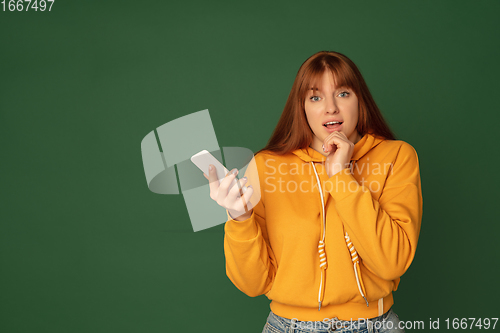 Image of Caucasian woman\'s portrait isolated on green studio background with copyspace