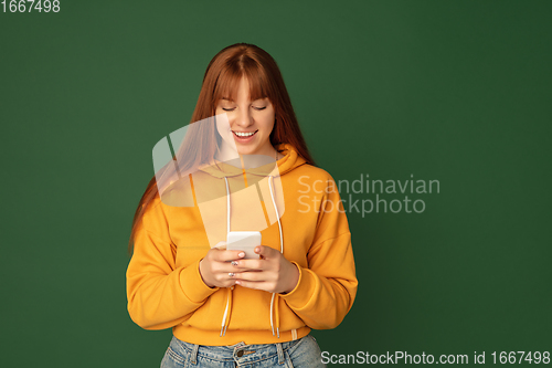 Image of Caucasian woman\'s portrait isolated on green studio background with copyspace