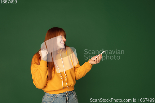 Image of Caucasian woman\'s portrait isolated on green studio background with copyspace