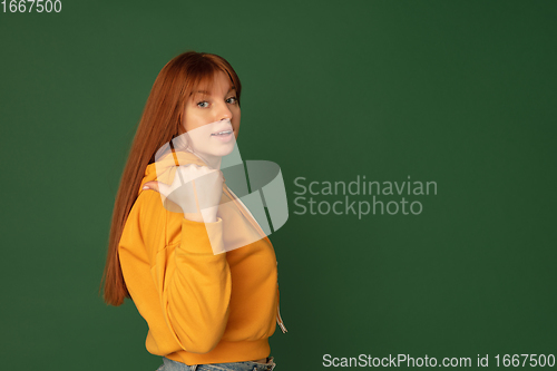 Image of Caucasian woman\'s portrait isolated on green studio background with copyspace