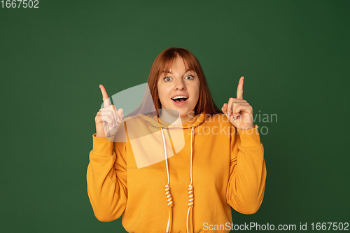 Image of Caucasian woman\'s portrait isolated on green studio background with copyspace