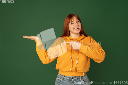 Image of Caucasian woman\'s portrait isolated on green studio background with copyspace