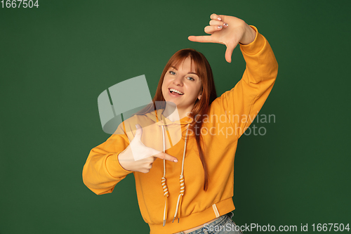 Image of Caucasian woman\'s portrait isolated on green studio background with copyspace