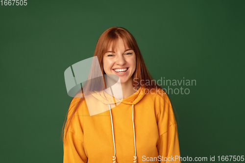 Image of Caucasian woman\'s portrait isolated on green studio background with copyspace