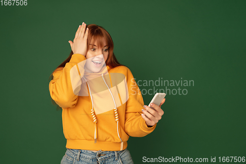 Image of Caucasian woman\'s portrait isolated on green studio background with copyspace