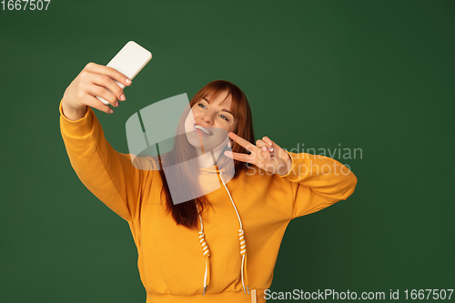 Image of Caucasian woman\'s portrait isolated on green studio background with copyspace