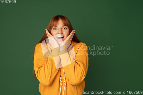 Image of Caucasian woman\'s portrait isolated on green studio background with copyspace