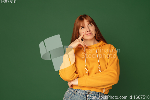 Image of Caucasian woman\'s portrait isolated on green studio background with copyspace