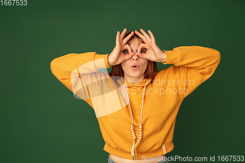 Image of Caucasian woman\'s portrait isolated on green studio background with copyspace