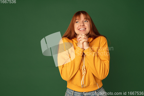 Image of Caucasian woman\'s portrait isolated on green studio background with copyspace