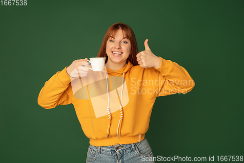 Image of Caucasian woman\'s portrait isolated on green studio background with copyspace