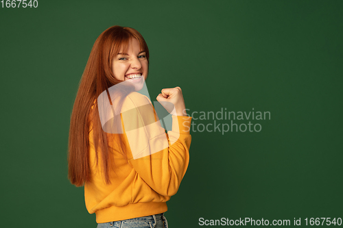 Image of Caucasian woman\'s portrait isolated on green studio background with copyspace