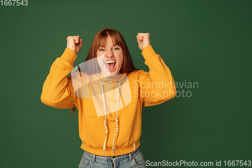 Image of Caucasian woman\'s portrait isolated on green studio background with copyspace