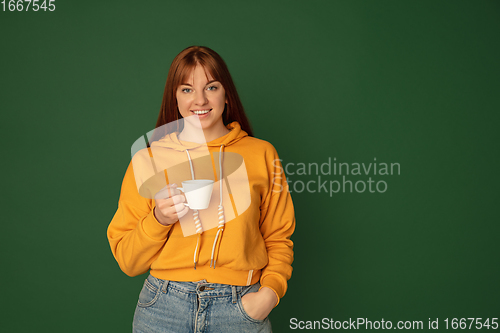 Image of Caucasian woman\'s portrait isolated on green studio background with copyspace