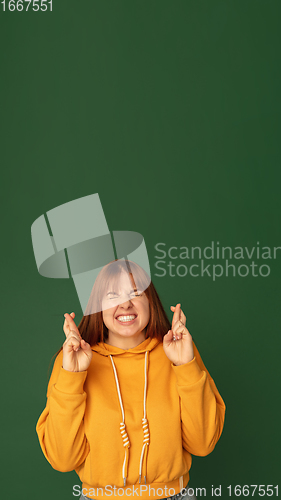 Image of Caucasian woman\'s portrait isolated on green studio background with copyspace, vertical flyer