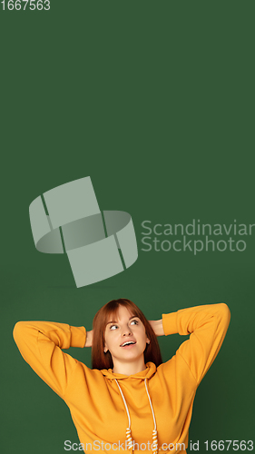 Image of Caucasian woman\'s portrait isolated on green studio background with copyspace, vertical flyer