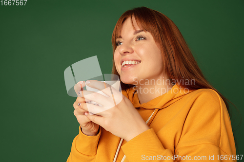 Image of Caucasian woman\'s portrait isolated on green studio background with copyspace