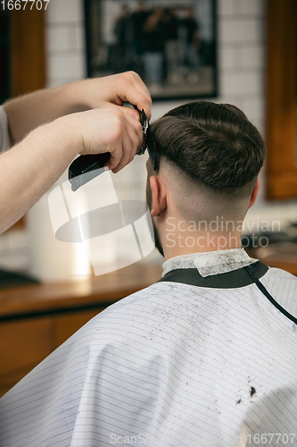 Image of Close up of client of master barber, stylist during getting care of hairstyle. Professional occupation, male beauty concept