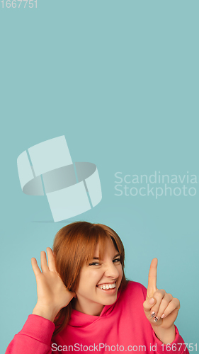 Image of Caucasian woman\'s portrait isolated on blue studio background with copyspace, vertical flyer