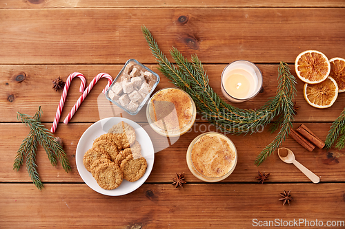 Image of glasses of eggnog, oatmeal cookies and fir branch