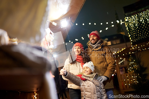 Image of happy family at christmas market in city