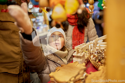 Image of happy family buying souvenirs at christmas market