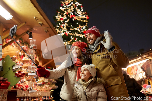 Image of happy family taking selfie at christmas market